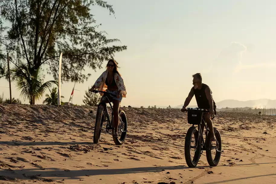 casal em frente a pousada Canto do Sol Praia andando de Bike